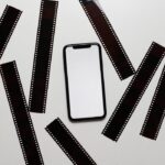 Film tapes scattered on table near smartphone